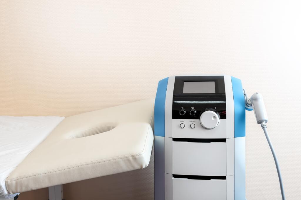Closeup,Detail,View,Of,Modern,Extracorporeal,Shock,Wave,Ultrasound,Eswt - Gardner Physical Therapy Electrotherapy and rehabilitation device next to treatment table at Gardner Physical Therapy.