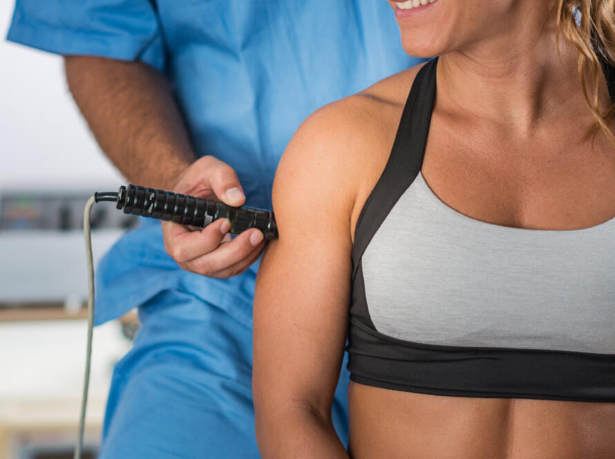 Gardner Physical Therapy specialist applying electrotherapy treatment to a female patient’s shoulder.