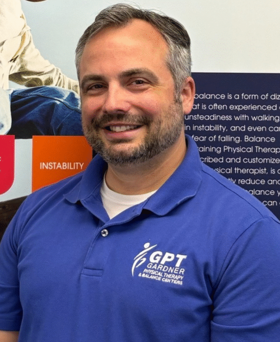Chris Gardner, physical therapist at Gardner Physical Therapy, standing in front of a Balance Health informational display.