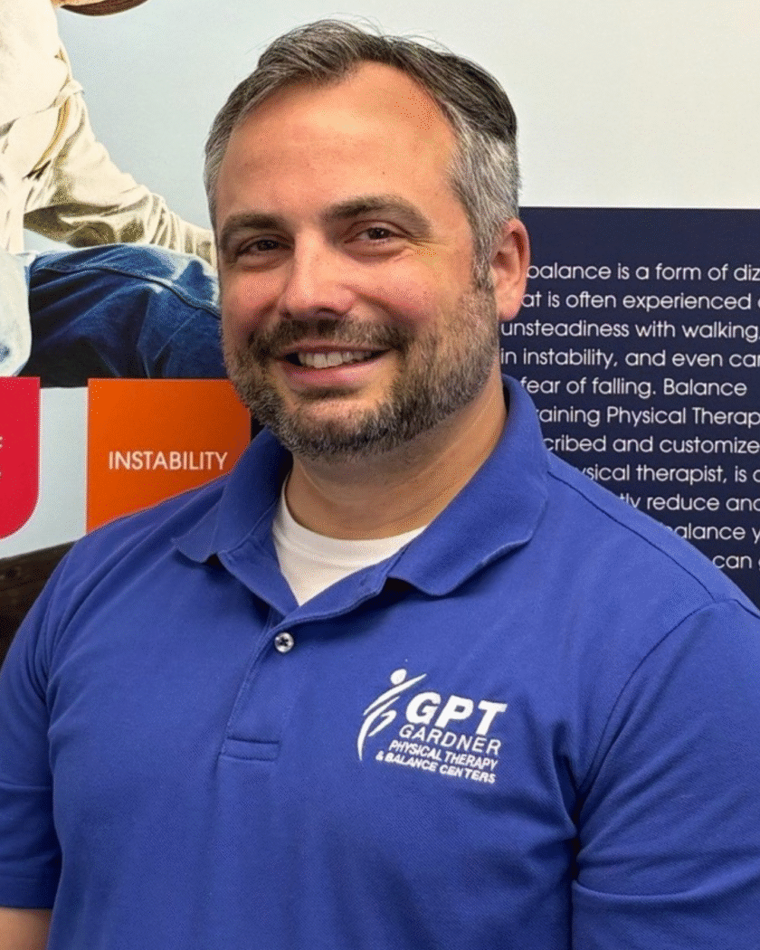 Chris Gardner, physical therapist at Gardner Physical Therapy, standing in front of a Balance Health informational display.