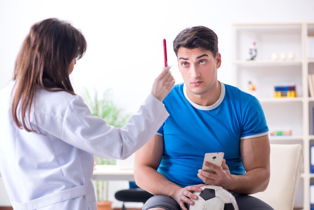 Football,Soccer,Player,Visiting,Doctor,After,Injury - Gardner Physical Therapy Physical therapist conducting eye-tracking test on young male athlete for concussion evaluation at Gardner Physical Therapy.