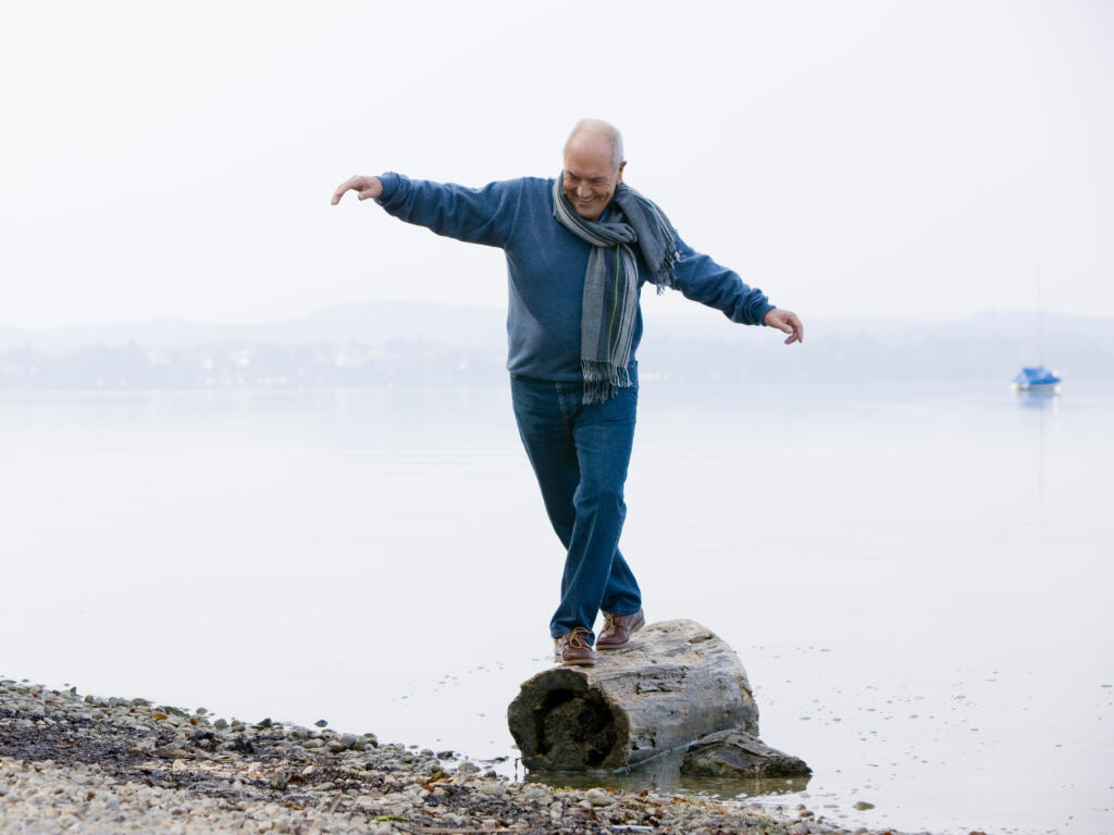 A,Senior,Man,Balancing,On,A,Log,At,The,Edge - Gardner Physical Therapy Balancing partial on a log, pain free. Gardner Physical Therapy