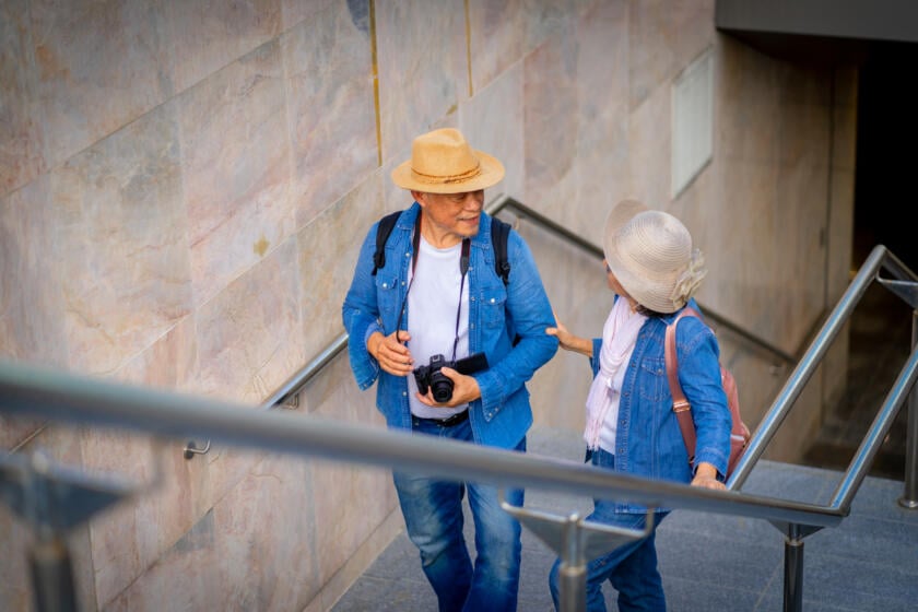 Older couple walking up stairs together, smiling and talking, promoting mobility with Alter G Gardner PT.