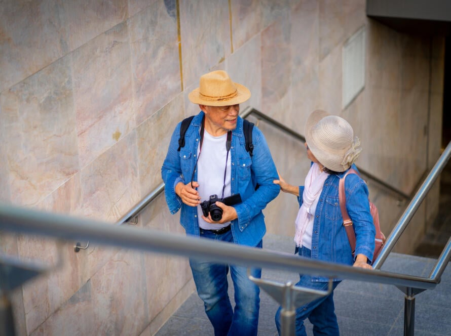 Older couple walking up stairs together, smiling and talking, promoting mobility with Alter G Gardner PT.