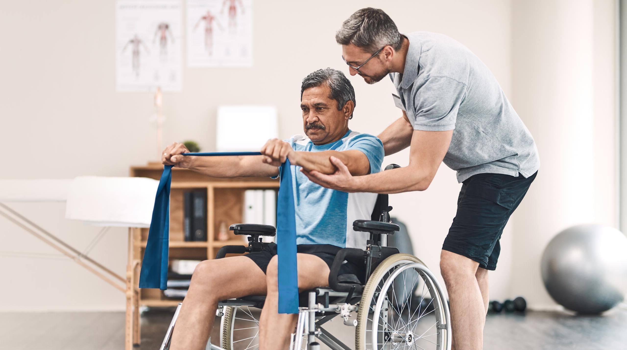 Therapist assisting wheelchair patient with resistance band exercises at Gardner physical therapy Ocean Pines.