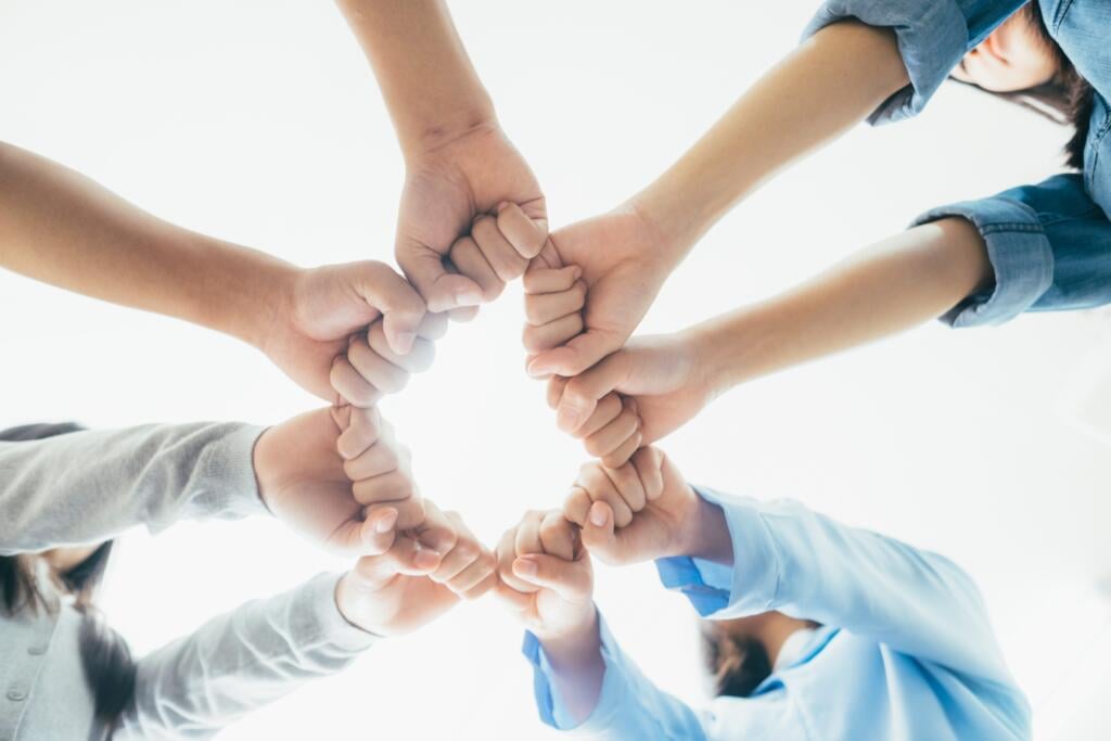 Hands forming a circle in unity, symbolizing teamwork and collaboration at Gardner Physical Therapy.